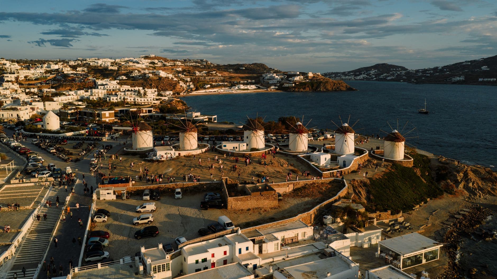 Captivating view of Mykonos windmills overlooking the Aegean Sea, highlighted by a beautiful sunset.