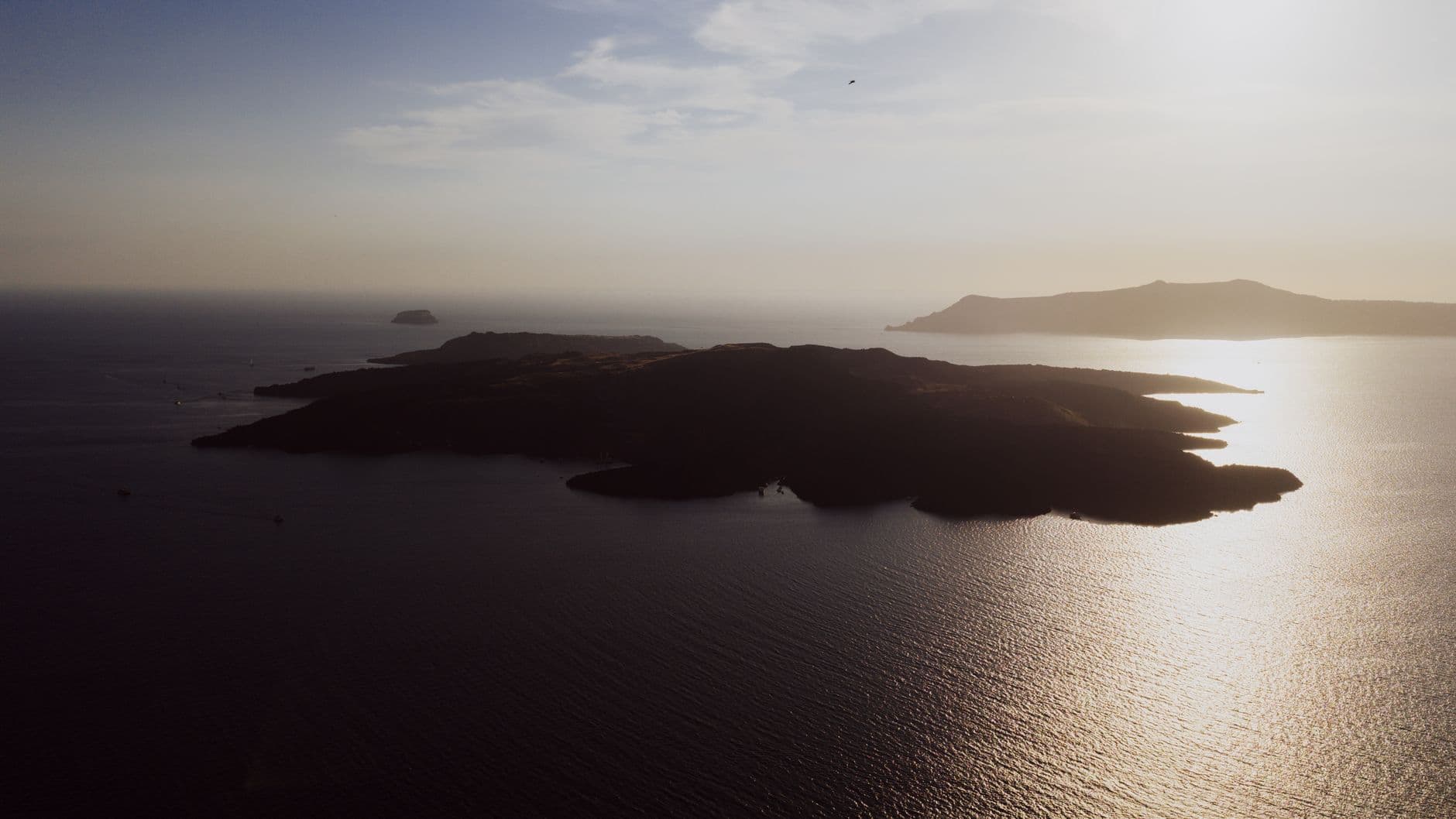 A stunning aerial view of the Greek islands in Fira at sunset. Serene seascape and sky.