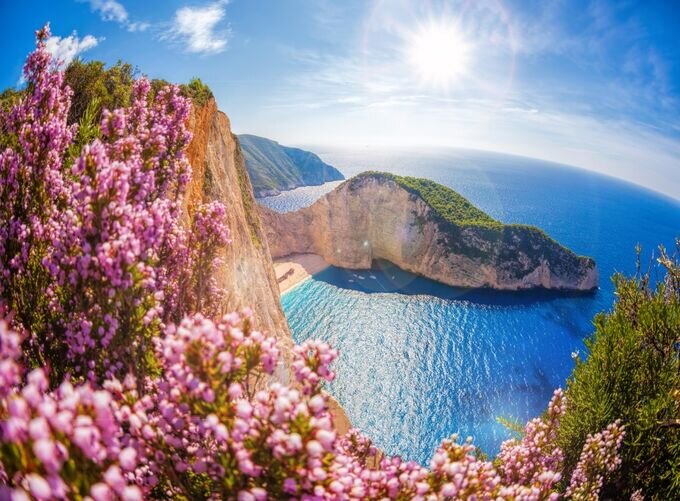 •  Navagio Beach on Zakynthos surrounded by steep limestone cliffs