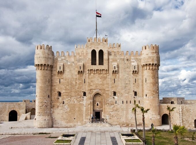 View of the Alexandria castle by the sea with stone walls and blue sky.