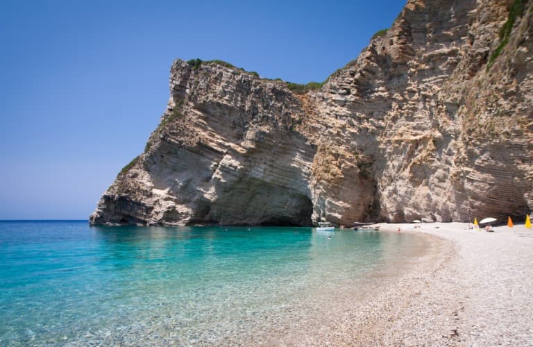 Beautiful beach scenery in Greece featuring crystal-clear turquoise sea, famous islands, and relaxing Mediterranean coastal atmosphere.