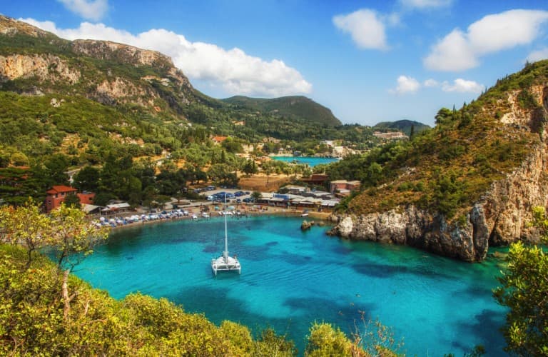 Scenic view of Hydra Island featuring historic Greek architecture, coastal nature, clear blue waters, and traditional Mediterranean atmosphere.