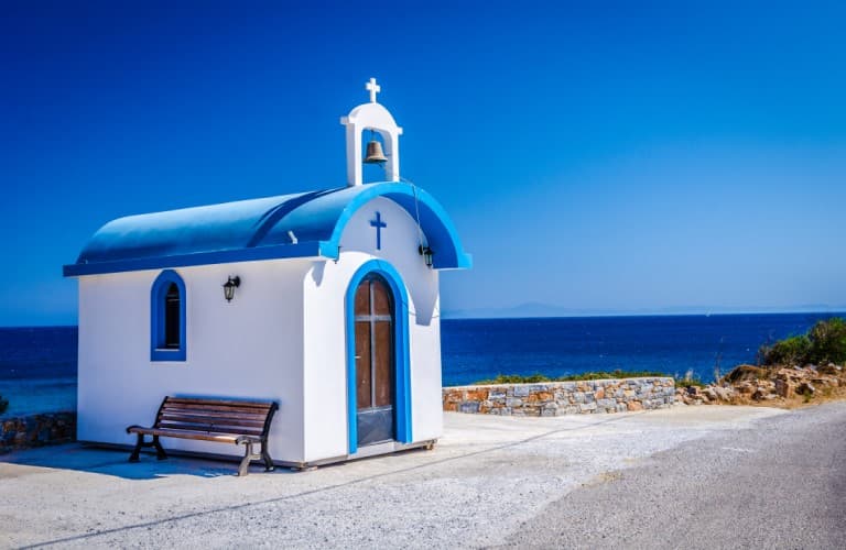 Beautiful view of Naxos Island featuring white houses, traditional windmills, blue Aegean Sea, and charming Greek island atmosphere