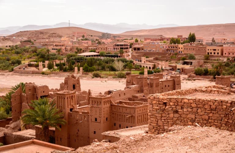 Beautiful view of traditional kasbah architecture surrounded by the stunning Atlas Mountains and natural landscapes in Morocco.
