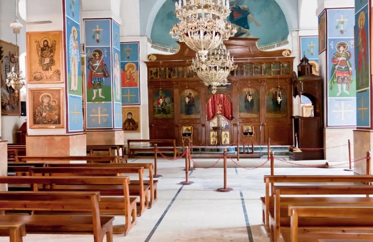 Ancient stone church interior in Madaba Jordan featuring historic mosaics and religious architecture with soft natural light highlighting the cultural heritage