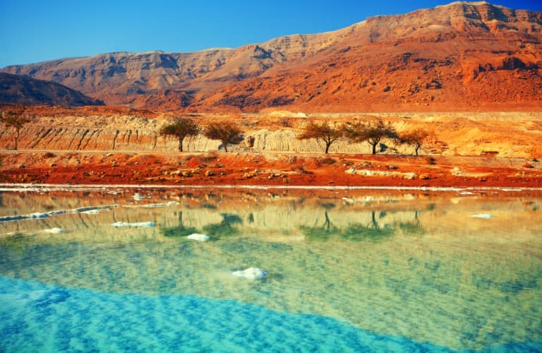 Stunning view of Wadi Mujib in Jordan featuring deep sandstone canyon walls, winding river pathways, and lush natural scenery ideal for adventure and nature travel experiences