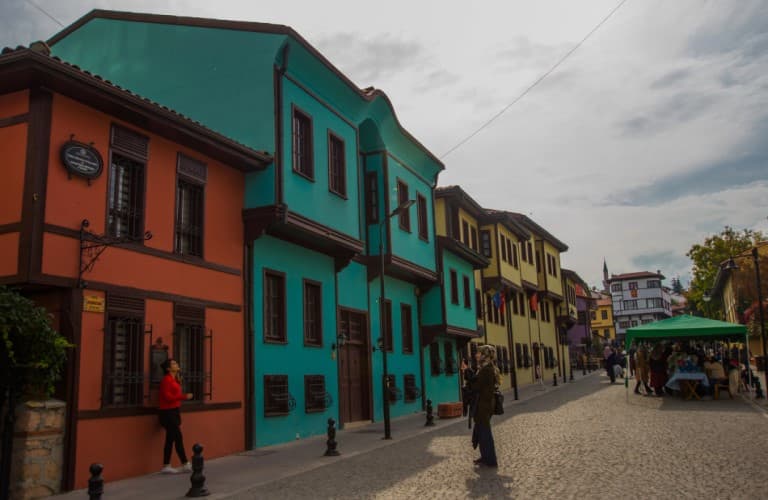 Tourists exploring the colorful streets of Odunpazarı in Eskişehir, surrounded by historic Ottoman houses and a vibrant cultural atmosphere.