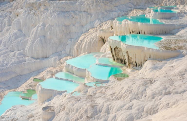 Pamukkale Travertines is a UNESCO World Heritage Site in Turkey, known for its stunning white terraces and thermal waters.